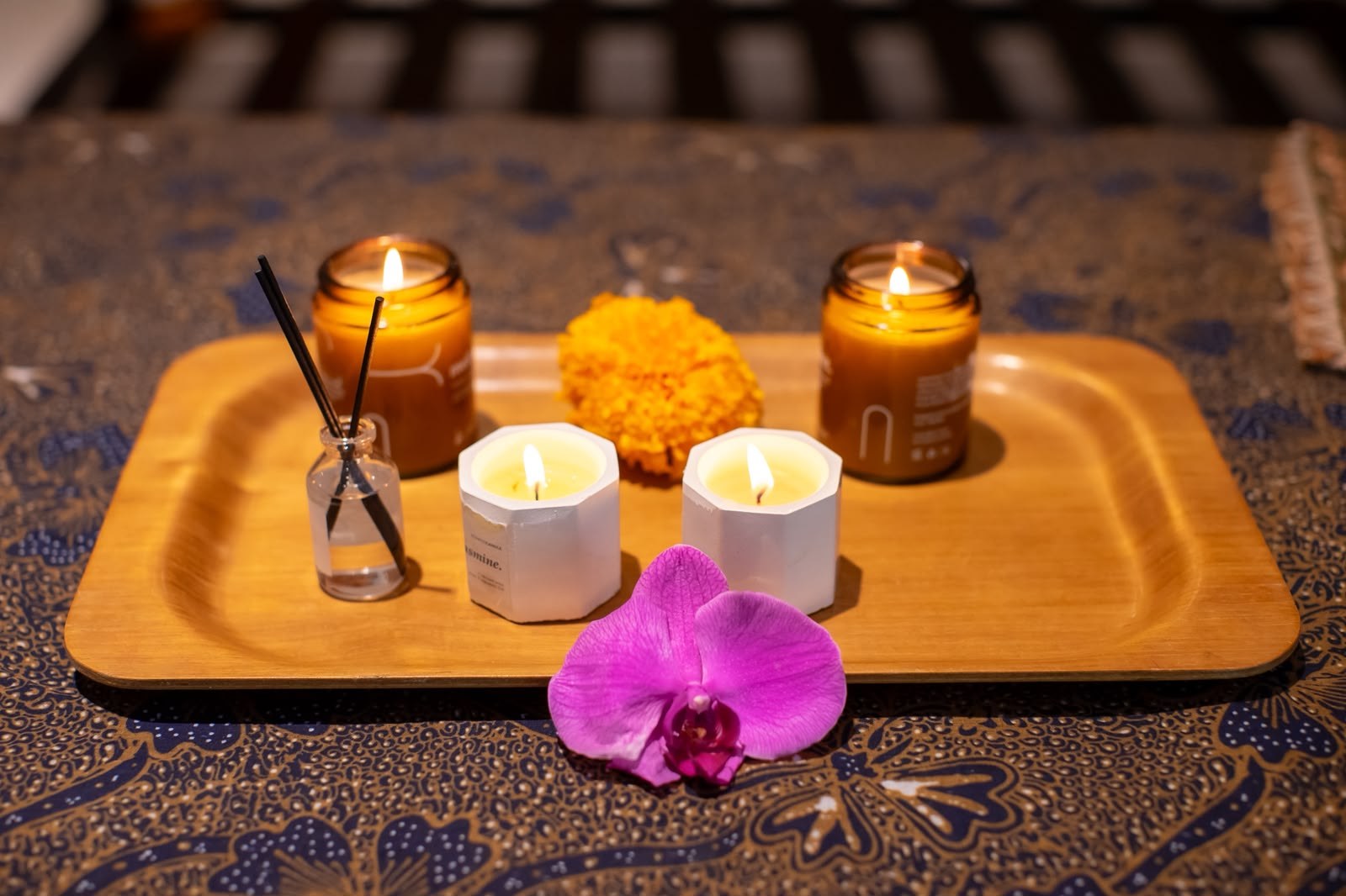 Candles and an orchid arranged on a spa tray