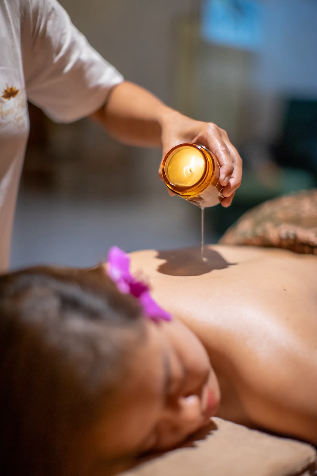 Warm oil being poured during a massage treatment