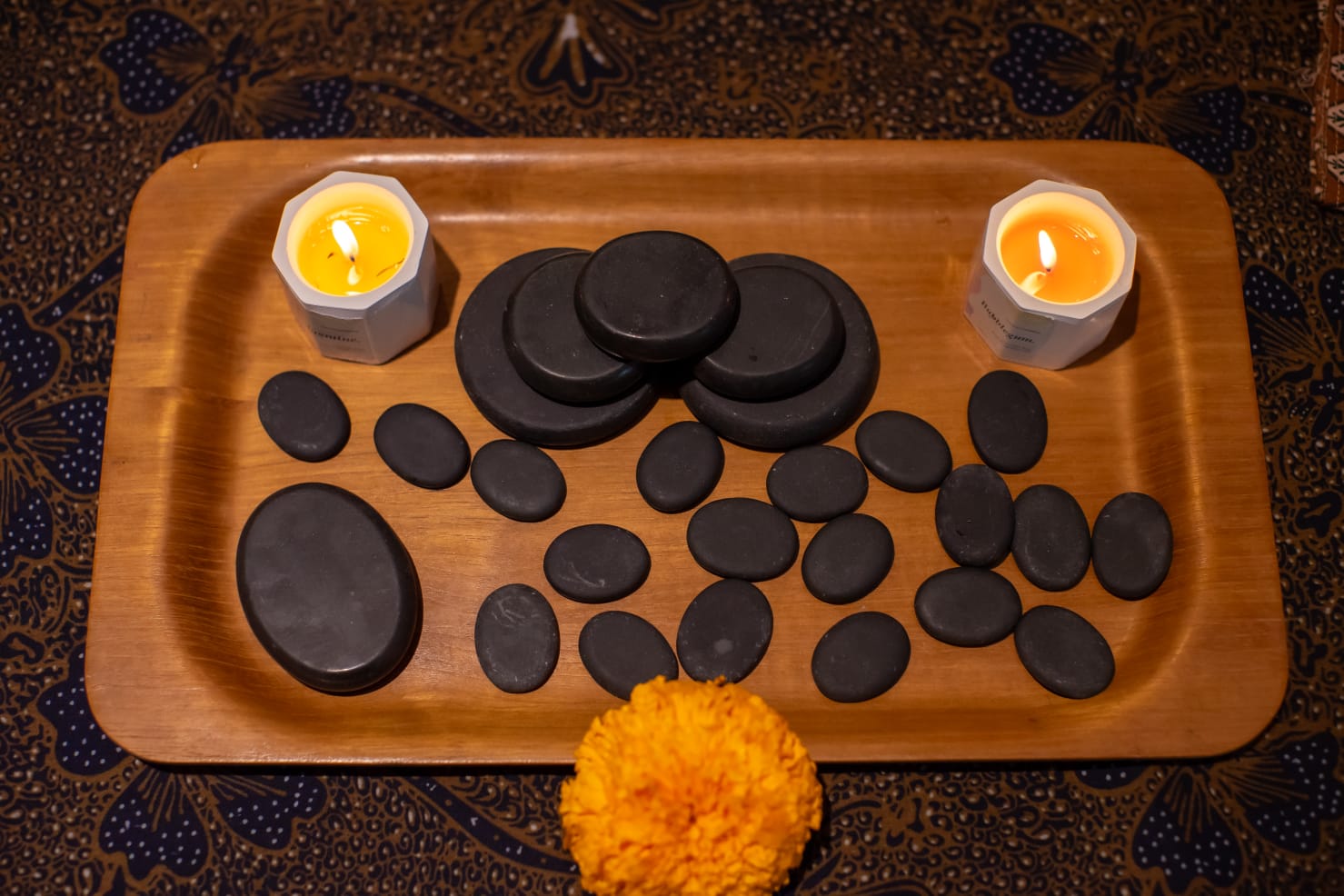Warm stones and candles prepared for a massage ritual