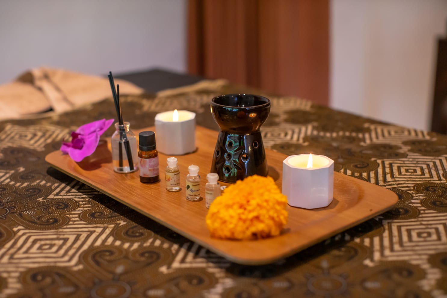 Aromatherapy oils and flowers on a wooden spa tray